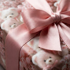 Pink teddy bear baby shower wrapping paper with a large satin ribbon bow by Wrapped Studios.