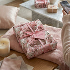 Pink teddy bear wrapping paper on a gift box with a pink bow and XOXO tag by Wrapped Studios.