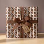 Cute teddy bear wrapping paper with a brown ribbon bow on a holiday gift box by Wrapped Studios.