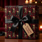 Red plaid teddy bear Christmas gift wrap with a black satin bow and gift tag by Wrapped Studios.