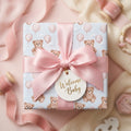 Pastel teddy bear baby shower wrapping paper with pink ribbon and Welcome Baby tag by Wrapped Studios.