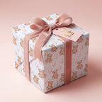 Teddy bear baby shower wrapping paper with pink velvet ribbon on a gift box by Wrapped Studios.