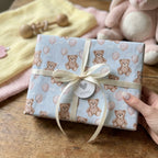 Teddy bear baby shower wrapping paper with a cream ribbon and heart tag by Wrapped Studios.