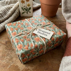 Sage green and orange botanical floral wrapping paper tied with rustic twine, by Wrapped Studios.