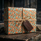 Rustic botanical floral wrapping paper in sage green and orange on a gift box, by Wrapped Studios.