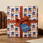 Tiger graduation wrapping paper with a rust ribbon and "Finally!" tag by Wrapped Studios.