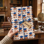 Tiger graduation wrapping paper with a blue twine bow and "Hooray!" tag by Wrapped Studios.