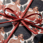 Illustrated Black woman wrapping paper with red flowers and raffia bow by Wrapped Studios.