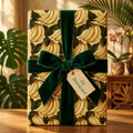 Banana wrapping paper with a green velvet bow and "Go Bananas" tag by Wrapped Studios.