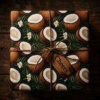 Wrapped Studios tropical coconut wrapping paper with lush leaves, white flowers, jute twine, and a "Cheers" gift tag.