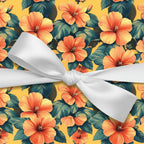 Bright yellow floral wrapping paper with orange hibiscus flowers and a white satin bow.