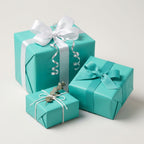 Elegant turquoise wrapping paper on square gifts with white satin ribbon & silver curly ribbon.