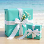 Two teal gift boxes wrapped with white ribbon & bows, adorned with baby's breath flowers.