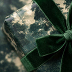 Vintage forest wrapping paper with a luxury green velvet ribbon bow by Wrapped Studios.