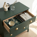 Forest print wrapping paper used as a luxury drawer liner in a green dresser, by Wrapped Studios.