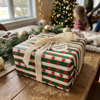 Red and green polka dot Christmas wrapping paper with cream velvet ribbon by Wrapped Studios.