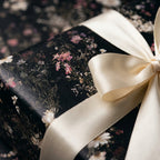 Luxury floral wrapping paper with vintage wildflowers and cream satin bow by Wrapped Studios.