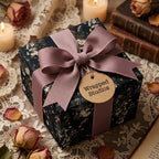 Dark vintage floral wrapping paper with a dusty rose ribbon on a gift box by Wrapped Studios.