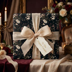 Luxury dark floral wedding gift wrap with cream bow and 'To The Happy Couple' tag by Wrapped Studios.
