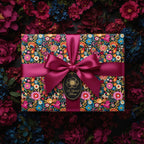 Rectangular gift wrapped in colorful floral wrapping paper with burgundy ribbon and "A Special Bloom" tag.