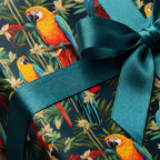 Gift wrapped in macaw parrot jungle print paper with teal ribbon.