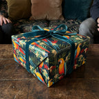 Gift wrapped in tropical parrot print wrapping paper with emerald velvet ribbon bow.