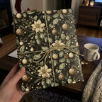 Elegant Christmas gift wrap featuring poinsettias and gold ornaments, tied with gold cord.