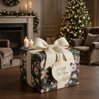 Luxury Christmas wrapping paper with elegant gold ornaments and cream ribbon by Wrapped Studios.