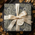 Luxury paisley wrapping paper in navy and olive green with a cream satin bow by Wrapped Studios.