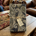 Elegant vintage paisley wrapping paper in navy and gold with a rustic twine bow, by Wrapped Studios.