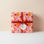 Vibrant abstract heart wrapping paper with a red ribbon and tag, perfect for romantic, Valentine's Day, or birthday gifts.