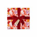 Abstract paint stroke wrapping paper in pink, orange, and red with a luxurious velvet red ribbon and gift tag, perfect for any celebration.