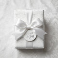 Elegant white and silver Christmas wrapping paper with a satin bow, by Wrapped Studios.