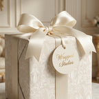 Luxury religious wrapping paper with vintage angel pattern, cream satin bow, and Wrapped Studios gift tag.