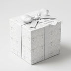 Elegant white angel wrapping paper on a luxury gift box with ribbon by Wrapped Studios.