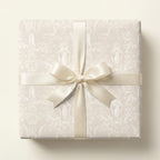 Vintage religious wrapping paper featuring angels in cream with a satin bow by Wrapped Studios.