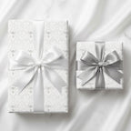 Elegant silver and white angel wrapping paper with satin bows, luxury gift wrap by Wrapped Studios.