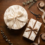 Elegant vintage angel wrapping paper on holiday gift boxes with satin and velvet ribbons by Wrapped Studios.