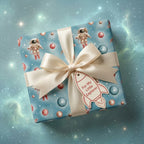 Kids outer space wrapping paper with astronauts on a gift box with cream bow, by Wrapped Studios.