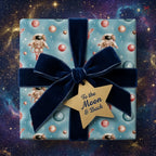 Outer space wrapping paper with astronauts and a navy velvet bow on a gift box by Wrapped Studios.