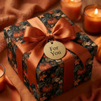 Luxury fall pumpkin wrapping paper with an orange satin ribbon on a gift box by Wrapped Studios.