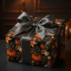 Elegant pumpkin wrapping paper with dark autumn floral patterns and a satin bow by Wrapped Studios.