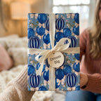 Blue balloon birthday wrapping paper with cream ribbon and Dream Big tag by Wrapped Studios.