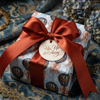 Vintage hot air balloon luxury gift wrap with a rust satin ribbon and "Up, Up & Away" tag by Wrapped Studios.
