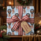 Vintage hot air balloon Christmas gift wrap with a red striped bow on a blue background, by Wrapped Studios.