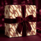 Baseball wrapping paper with a luxury burgundy velvet bow on a gift box by Wrapped Studios.