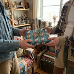 Retro electric guitar wrapping paper on a gift being exchanged, by Wrapped Studios.