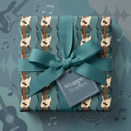 Teal guitar wrapping paper with a matching bow and gift tag from Wrapped Studios, perfect for music lovers.
