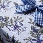 Blue floral wrapping paper with watercolor wildflowers and a gingham ribbon bow by Wrapped Studios.