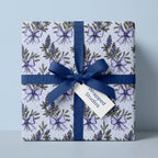 Blue floral wrapping paper with lupines and a navy bow, elegant gift wrap by Wrapped Studios.